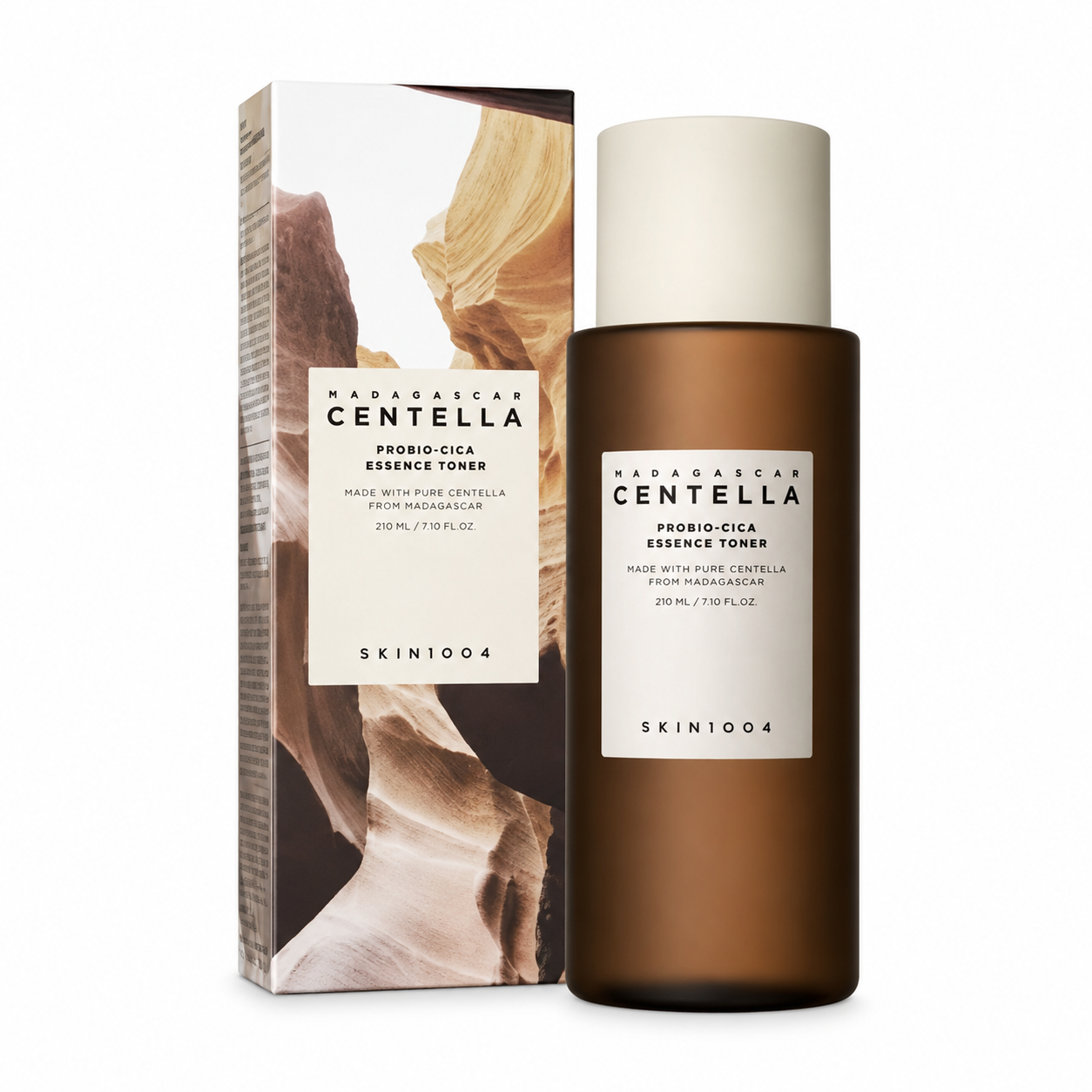 A bottle of SKIN1004 Madagascar Centella Probio-Cica Essence Toner in a dark amber container next to its white and brown landscape-patterned product packaging box.