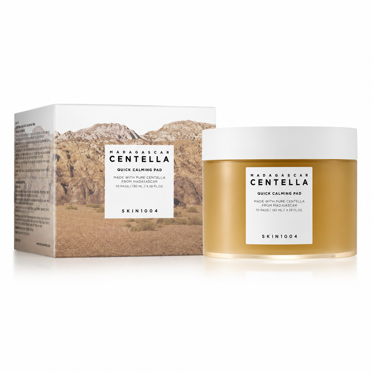 SKIN1004 Madagascar Centella Quick Calming Pad skincare product featuring the outer cardboard box with a desert landscape design next to the clear amber round tub of 70 toning pads.
